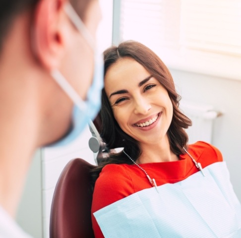 Woman smiling at dental team member