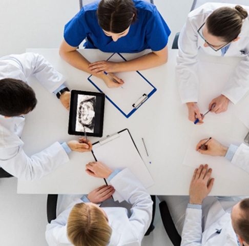 Overhead shot of a dental team in Jeffersonville discussing patient charts