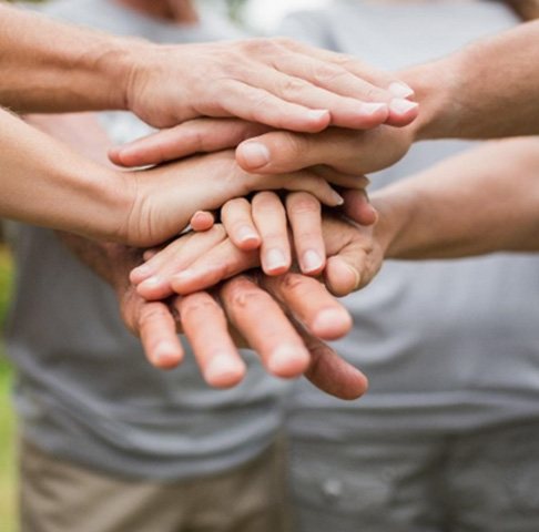 Closeup of multiple hands put together in a symbol of community