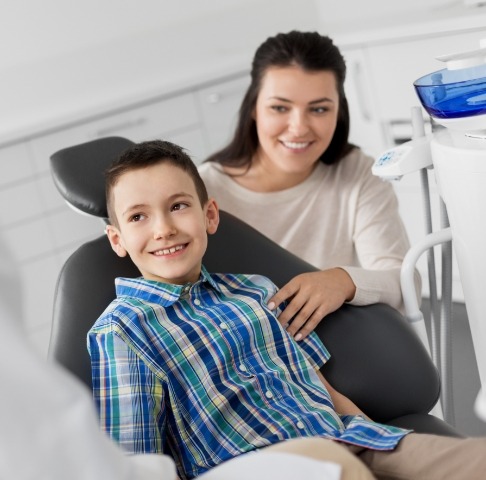 Young boy and mother smiling during dental checkups and teeth cleanings children's dentistry visit