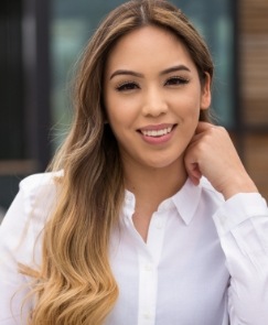 Woman smiling after receiving treatment for head neck and jaw pain