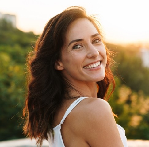 Woman sharing healthy smile thanks to preventing dental emergencies