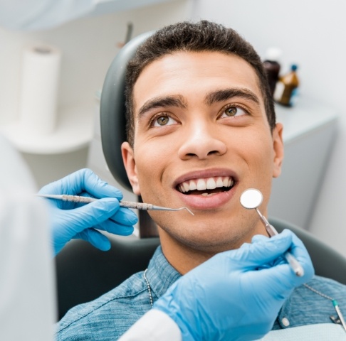 Man smiling up at his dentist after a dental emergency in Jeffersonville