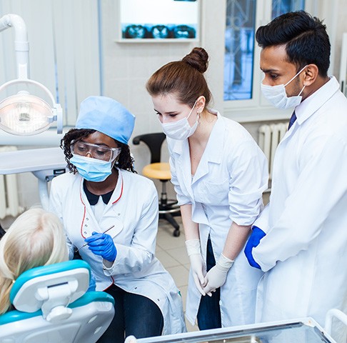 Dental students working with a patient