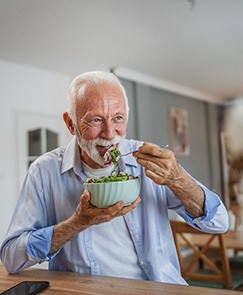 Man smiling while eating lunch at home