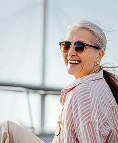 Senior woman smiling while relaxing on boat