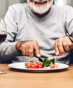 Man with dental implants in Jeffersonville eating steak