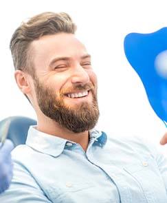 Young man admiring his new dental implants in Jeffersonville