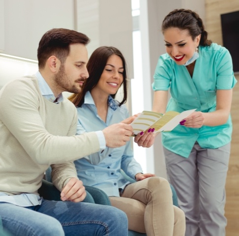 Dental team member giving patients dental insurance information