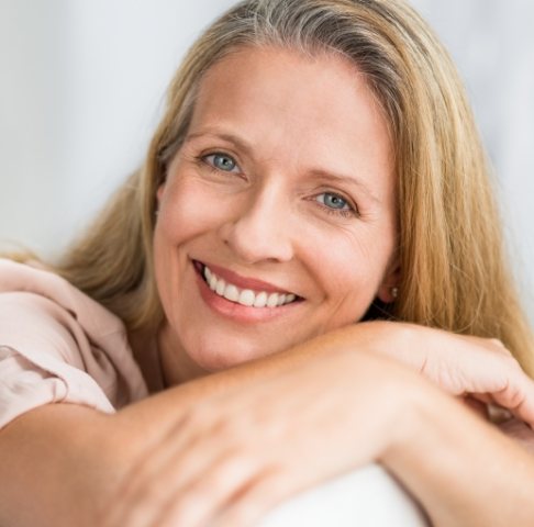 Woman sharing smile after dental implant tooth replacement