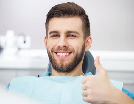 Alert man smiling and giving a thumbs-up after nitrous oxide sedation