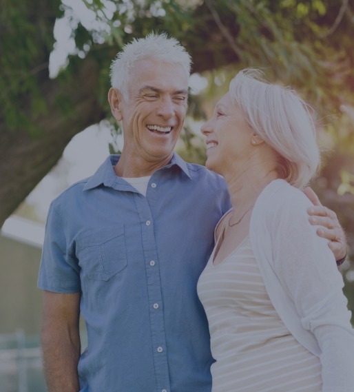 Man and woman with healthy smiles after restorative dentistry