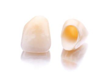 Closeup of two metal-free dental crowns on a white background